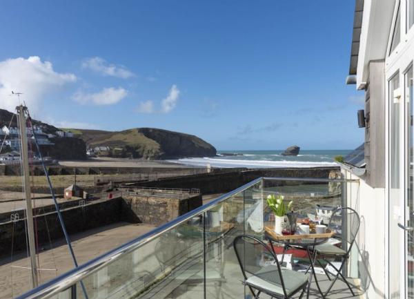 Balcony with table and chairs and a sea view.