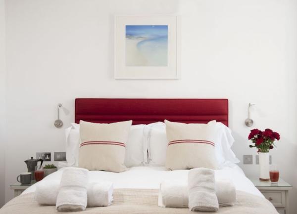 Double bedroom with bedside tables, table lights and towel sets.