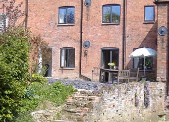 A 3-storey, brick-built mill conversion alongside the mill raace.