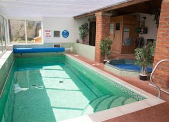 A heated indoor swimming pool with a hot tub.