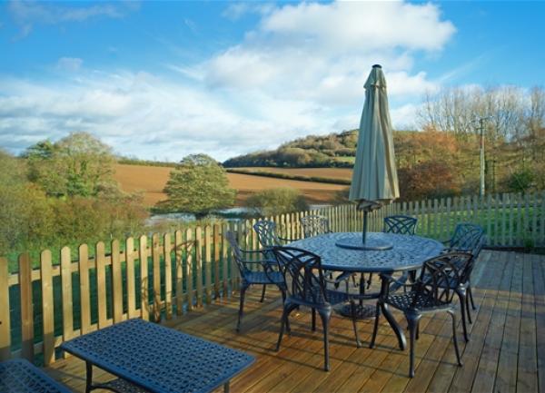 Outdoor dining table and chairs on a deck with fine rural views.