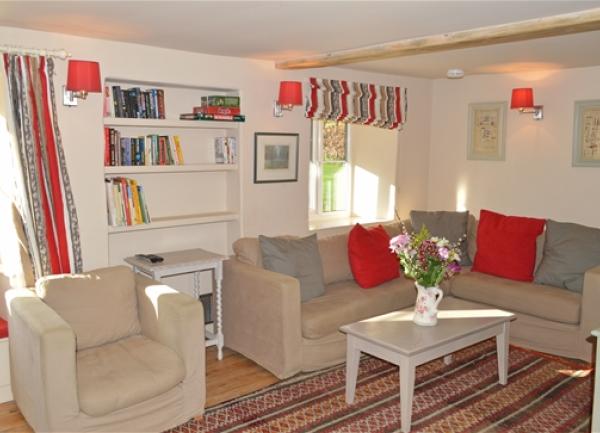 Lounge with a corner sofa, bookshelf, armchair and coffee table.