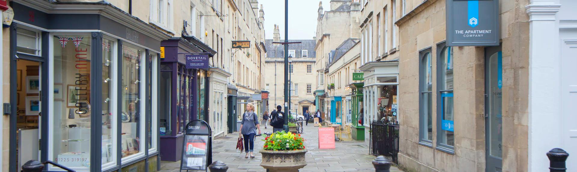 A pedestrian street in Bath showing Georgian buildings and shop frontss