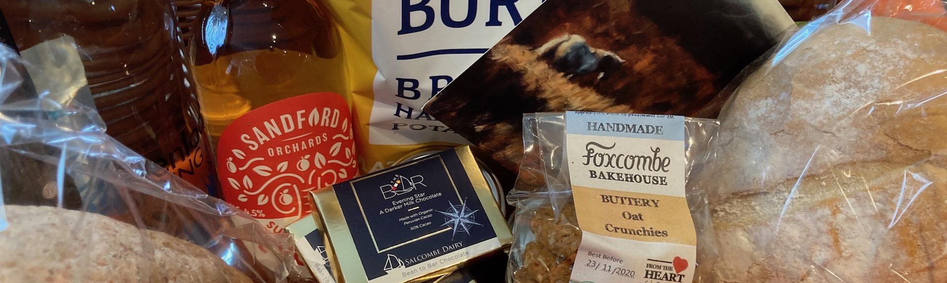 A holiday cottage welcome pack featuring luxury food and drink items