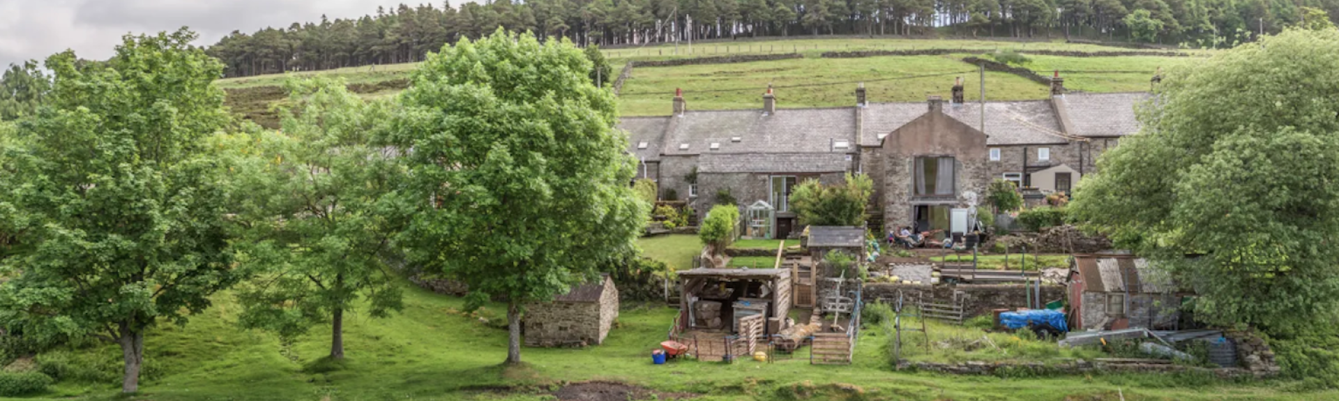 A large, stone-built, Pennine holiday home surrounded by trees and open fields