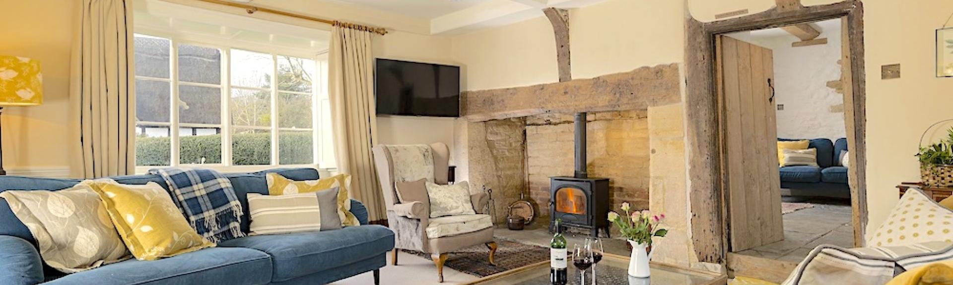 A lounge with oak beams, inglenook, cosy sofas and coffee table.