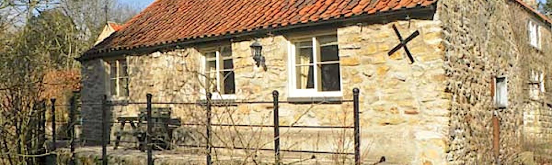 Exterior of a stone-built, single-storey stable converted to a holiday cottage.