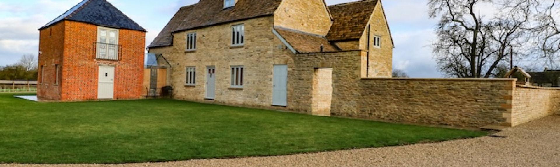 C Cotswold Farmhouse with a large outbuilding and walled garden.