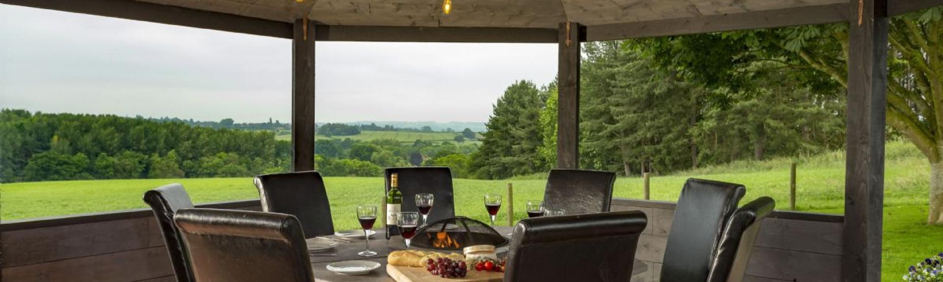 A table for eight beneath a pergola with far-reaching rural views.