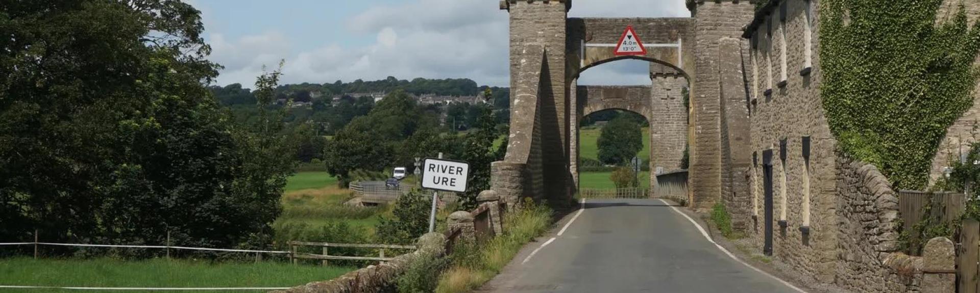 The road entering Leyburn runs under a stone-built arch.