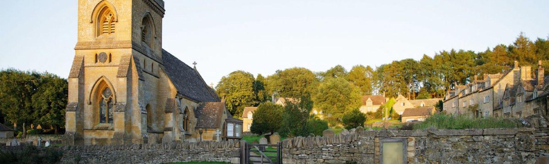 A Cotswold church and a cluster of honeystone cottages.