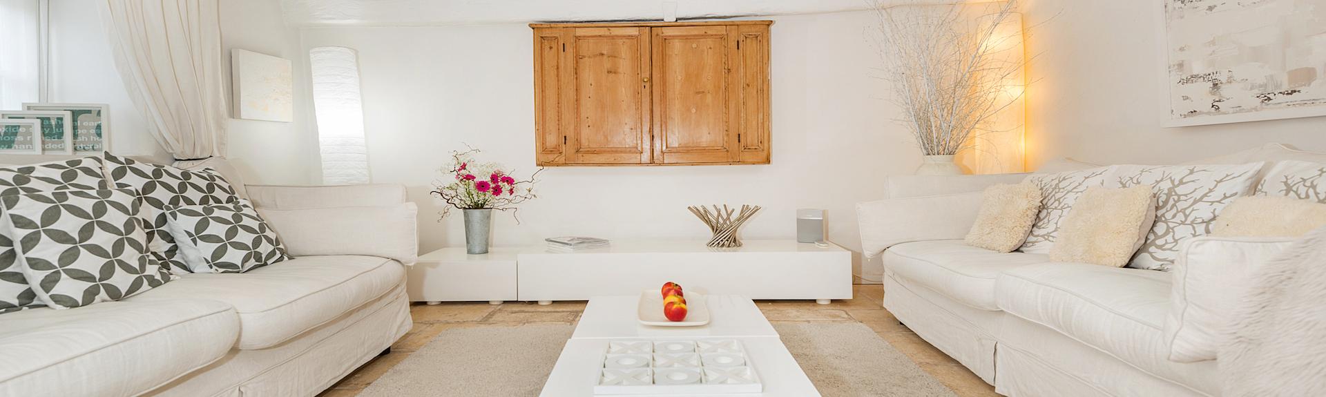 An luxury eco cottage lounge, with soft furnishings all in white