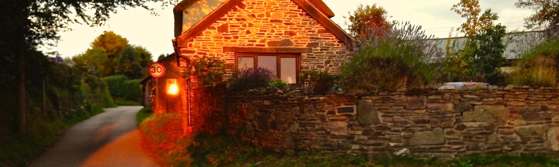 An autumn sunset lights up the stone walls of a North Devon holiday cottage