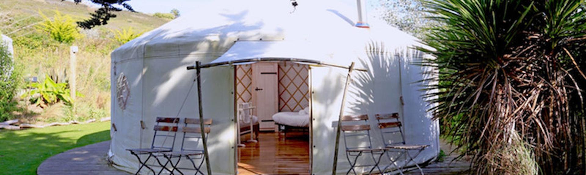 A Cornish eco-yurt with a glimpse of its polished wooden floor and double bed