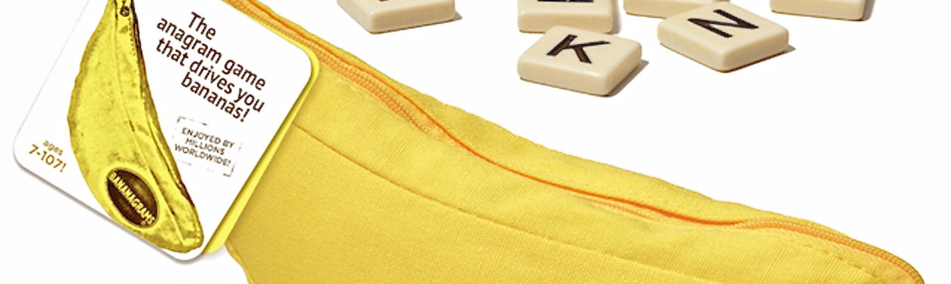 Image of the box cover for Banannagame, in the shape of a zip-up banana, with some   little plastic squares each containing a letter.