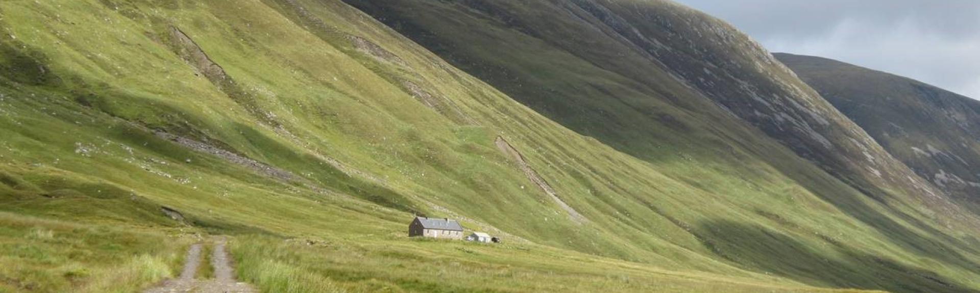 A remote stone-built shooting lodge nestles in the lee of a Scottish mountainside.