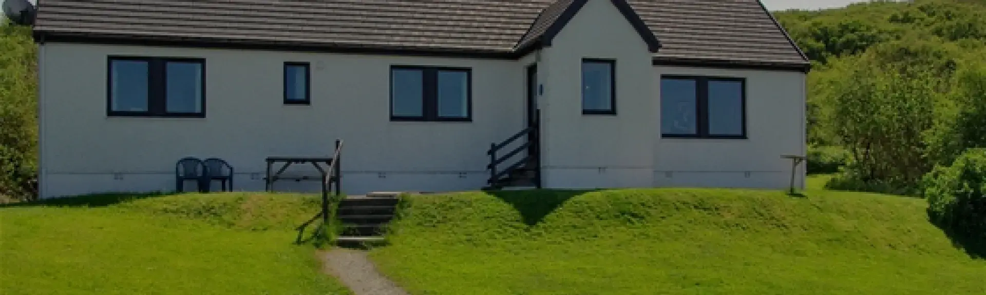 A secluded holiday bungalow surrounded by lawns in the Scottish countryside.