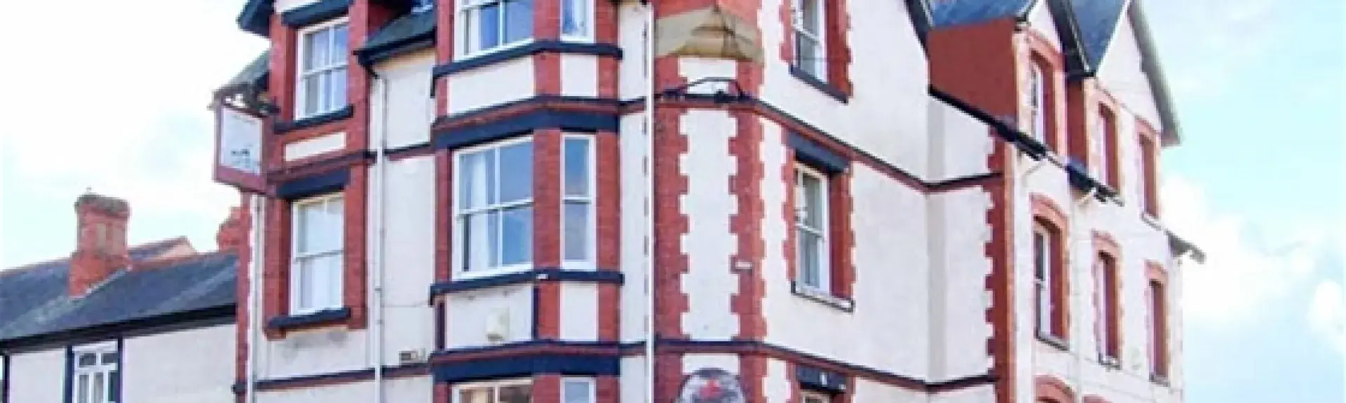 Exterior of a large 3-Victorian Inn  on a street corner, now converted into a big holiday cottage.