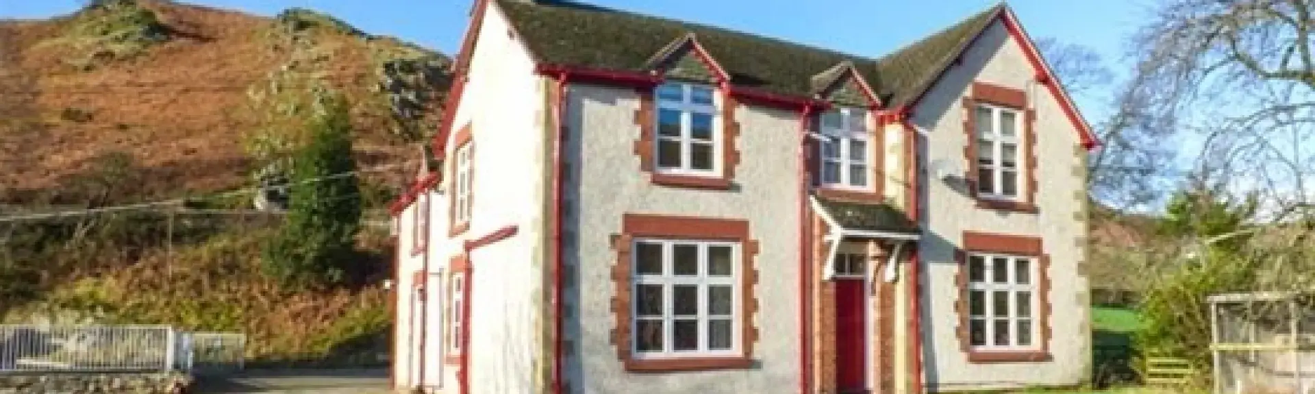 A double-fronted 2-storey house with a large lawn in a moorland location