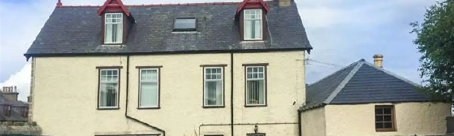 3-storey house with a 2-storey wing and a large parking space in front