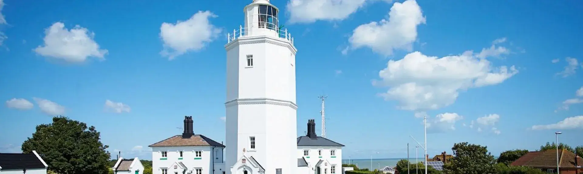 A lighthouse and buildings now converted to holiday cottages gleams in the summer sun in Broadstairs.