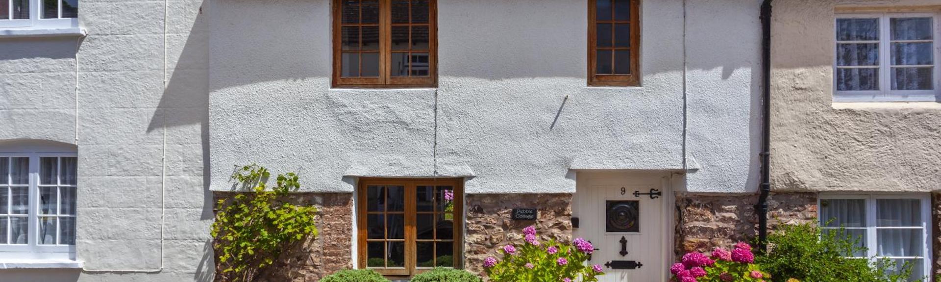 Exterior of a terraced stone-built holiday cottage in Dunster.