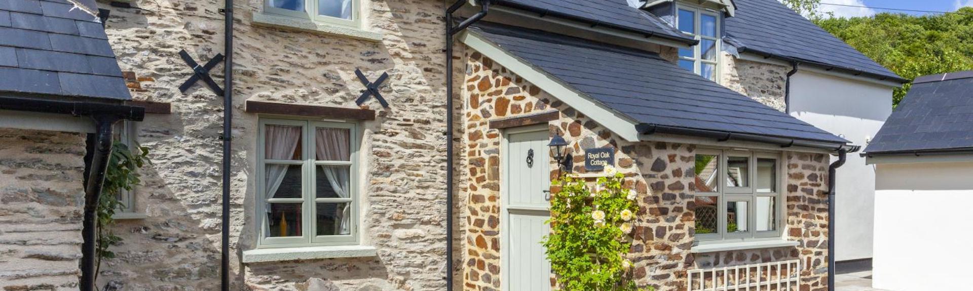 Exterior of a traditional stone-built Exmoor cottage overlooking a quiet village lane.
