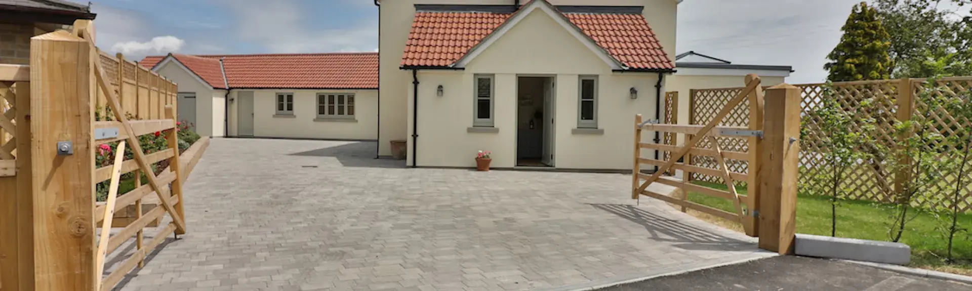 Atwin-gabled contemporary house with a large drive and secure fenced garden.