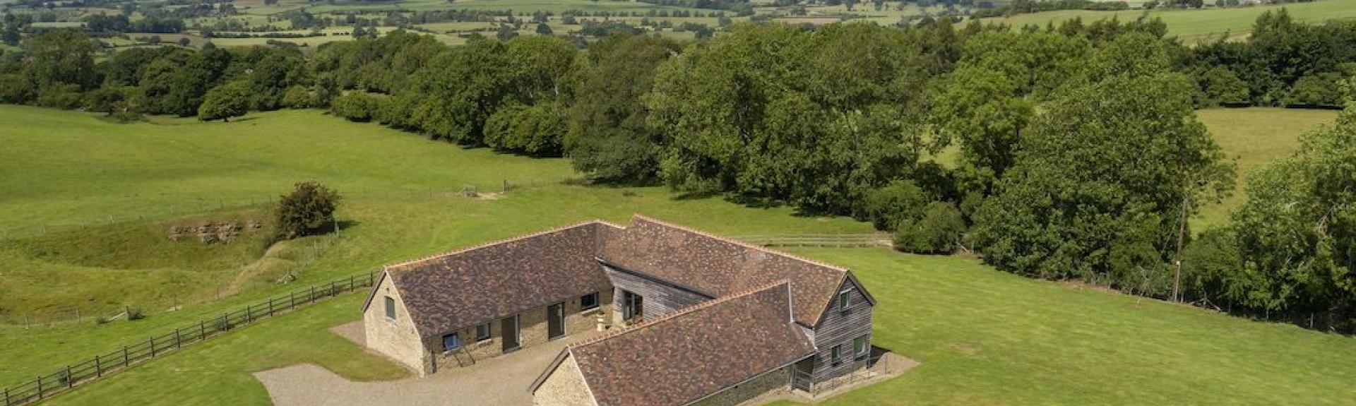 Aerial image of a Shropshire holiday barn surrounded by open fields and woods.