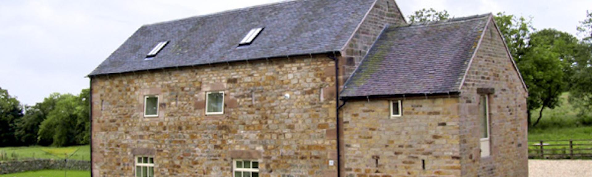 Exterior of a 2-storey, stone-built,  barn conversion in a rural Peak District location.