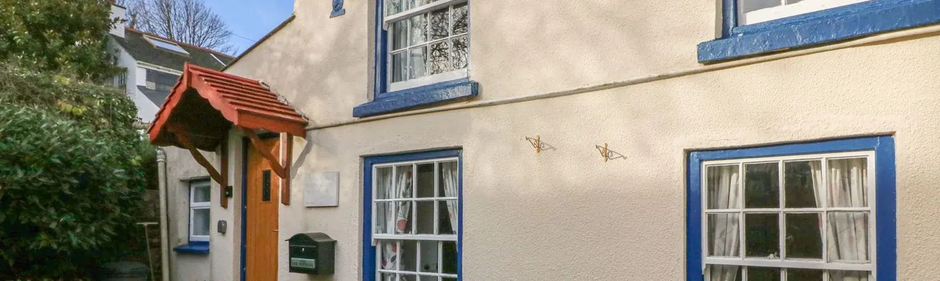 Exterior of asemi-detached restored fisherman's cottage with a paved courtyard in Appledore.