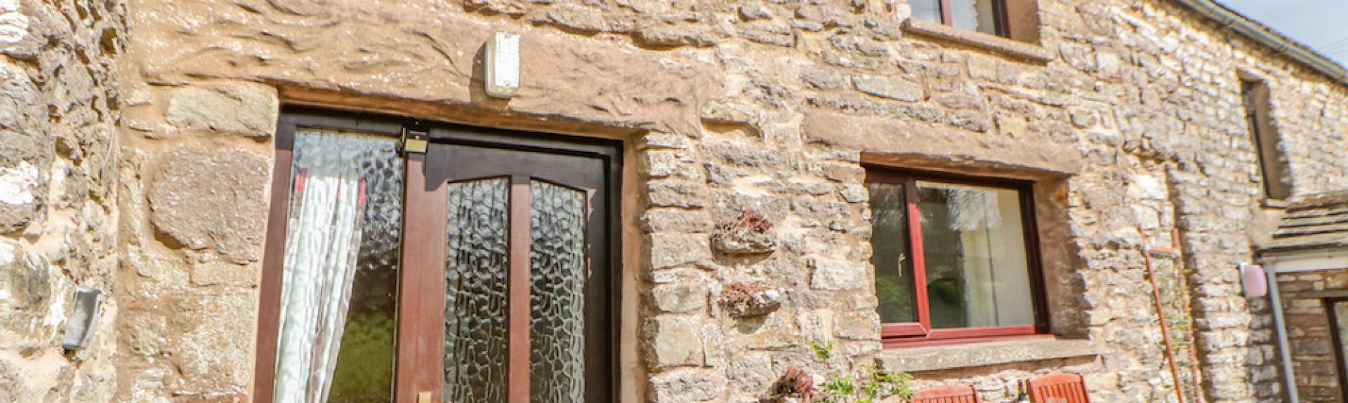 A 2-storey, stone-built holiday cottage in Cumbria overlooking a sunny courtyard