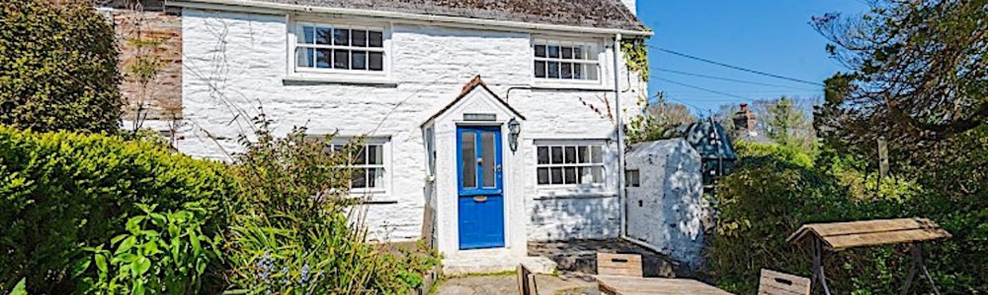 A stone-built Feock holiday cottage overlooks a flagstone patio with outdoor tables and chairs