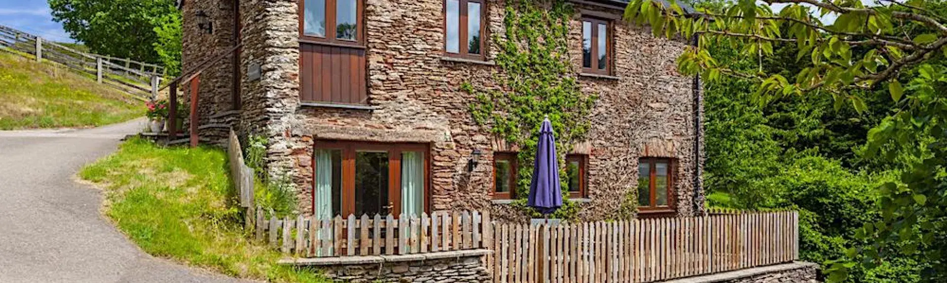 Exterior of an Exmoor Barn conversion on a bend in an empty country lane.