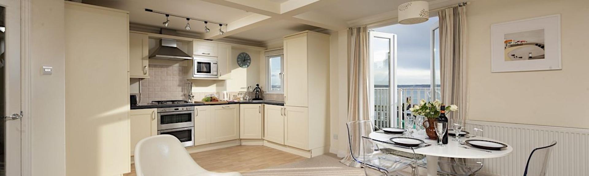 Open plan room containing a kitchen and dining area.