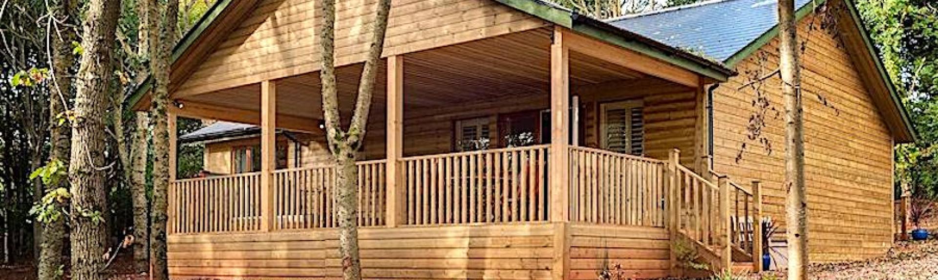 Exterrior of an eco lodge with a  covered deck and hot-tub.