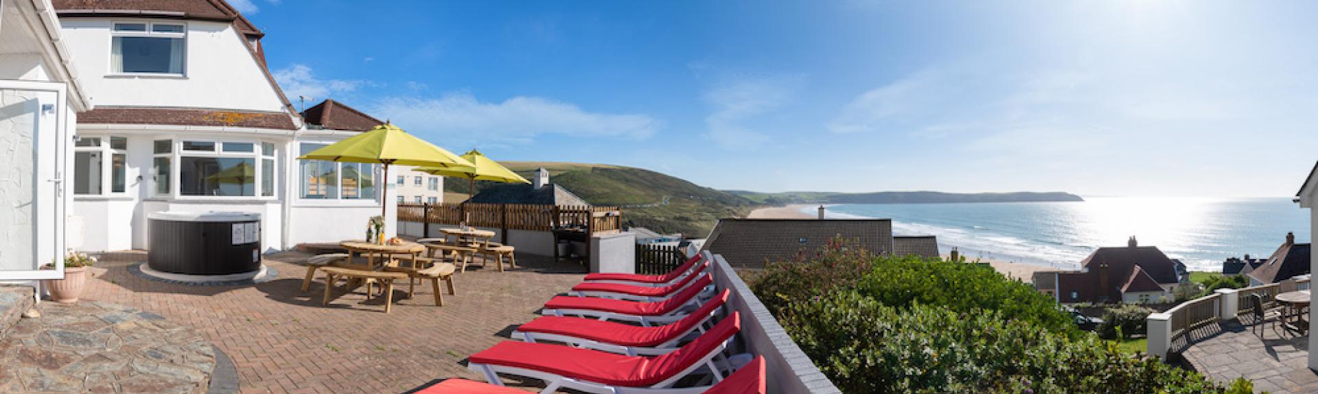 A 2-storey holiday cottage with a large sun terrace overlooks a sandy beach.