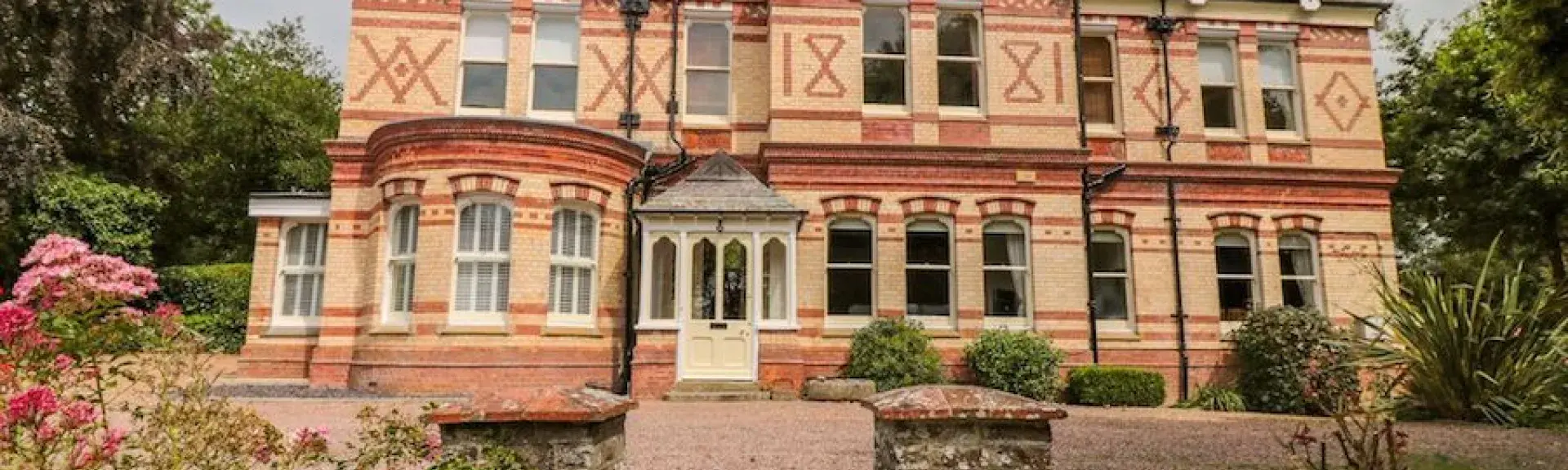 Large, 2-storey, Victorian house with a tree-lined garden