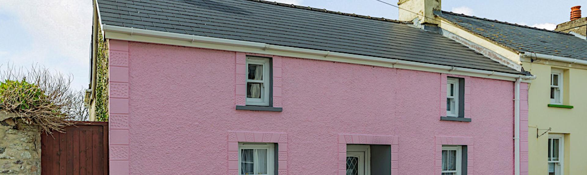 A double-fronted Pembrokeshire holiday cottage overlooks a quiet lane.
