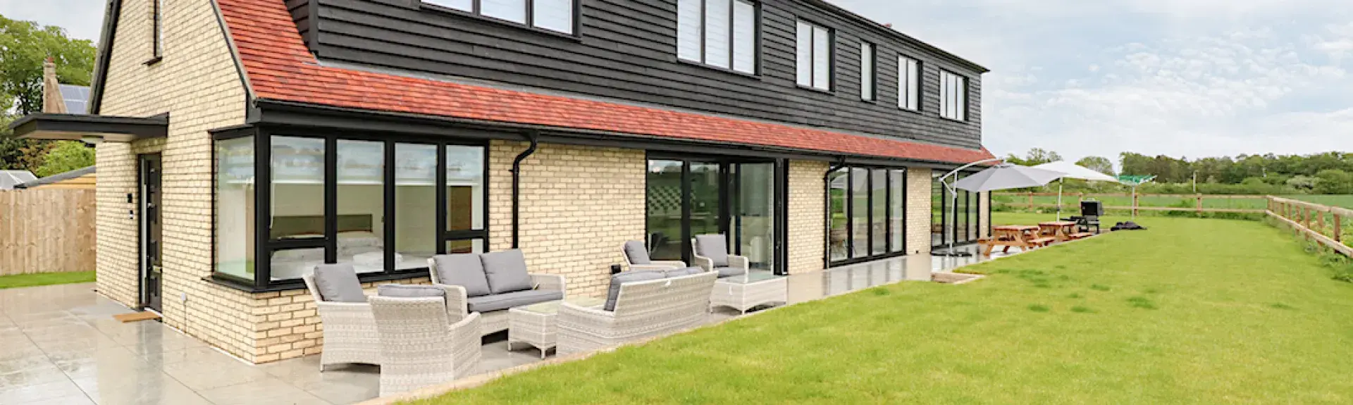 A contemporary 2-storey brick house surrounded by open fields.