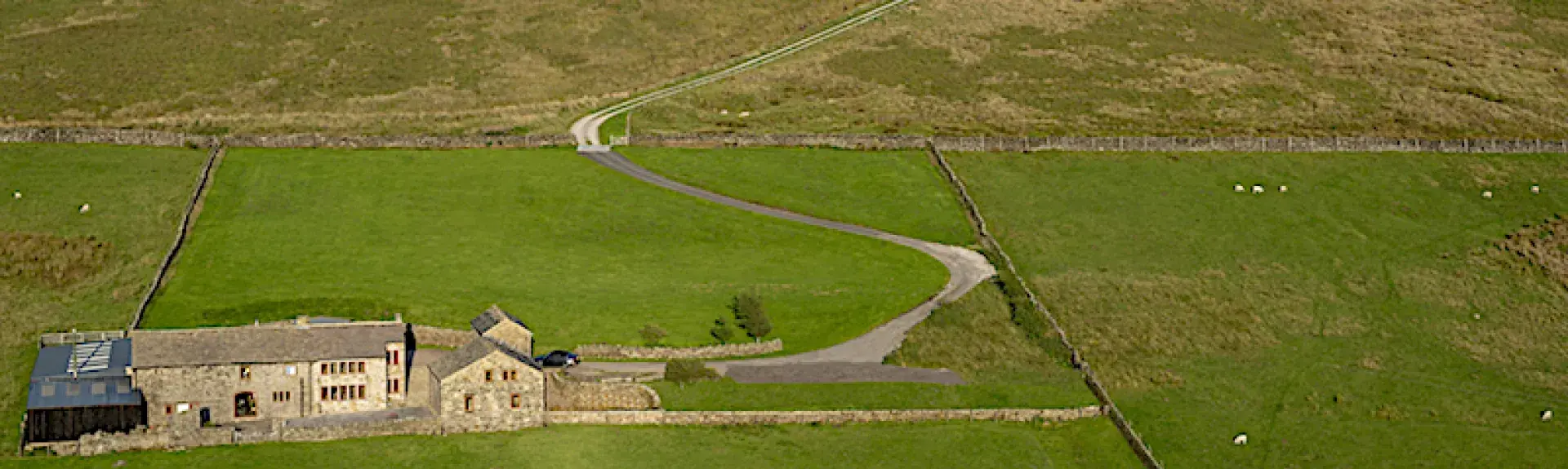 An isolated Pennine farm house is surrounded by empty moorland.
