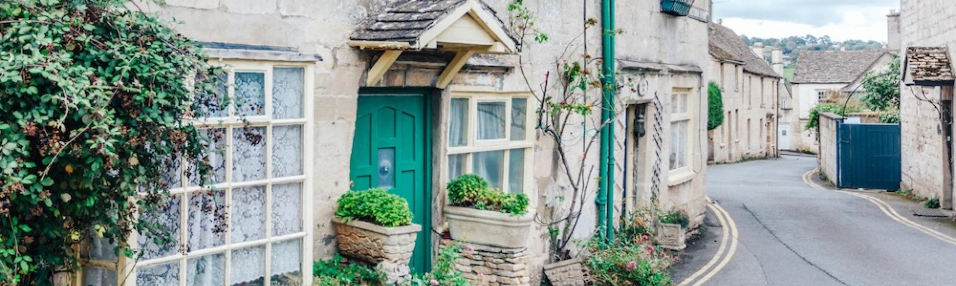Exterior of a terraced Cotswold holiday cottage overlooking a village street.