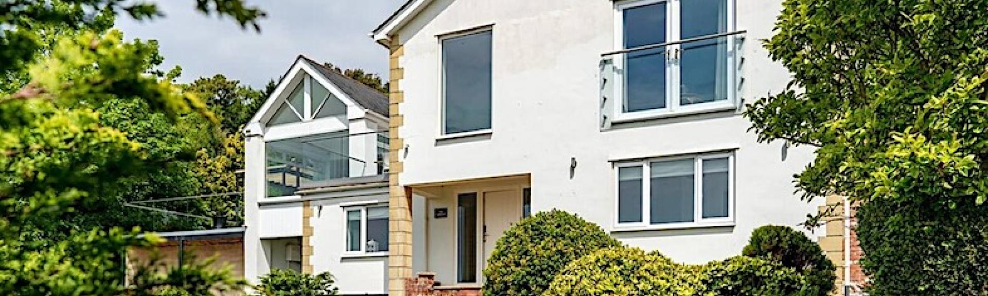A large 2-storey Teignmouth holiday home overlooks a shrub-filled garden.