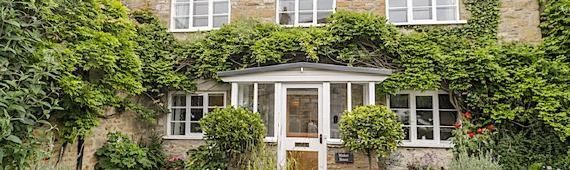 Exterior of a double-fronted, wisteria-clad Abbotsbury holiday cottage