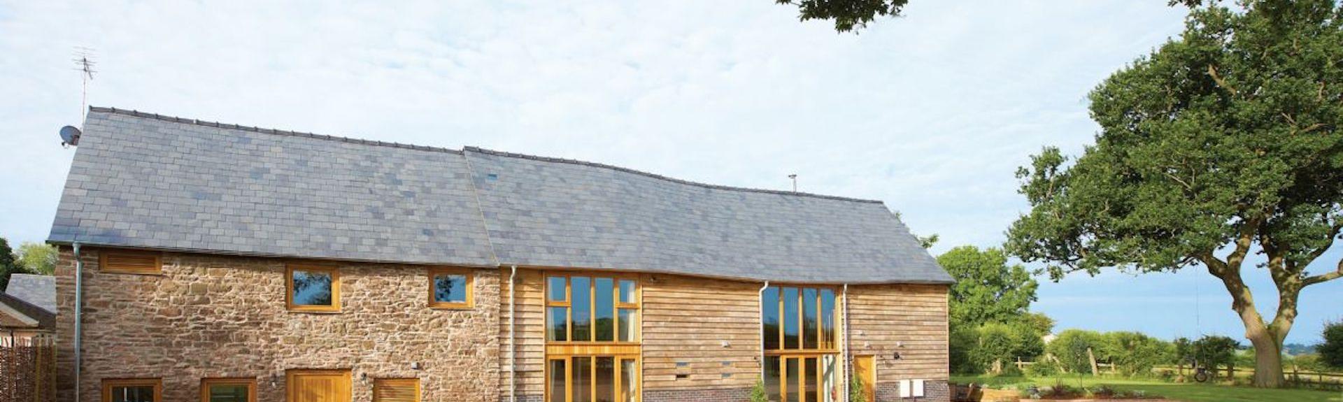 Bromyard barn conversion with large floor-height windows, in open countryside.
