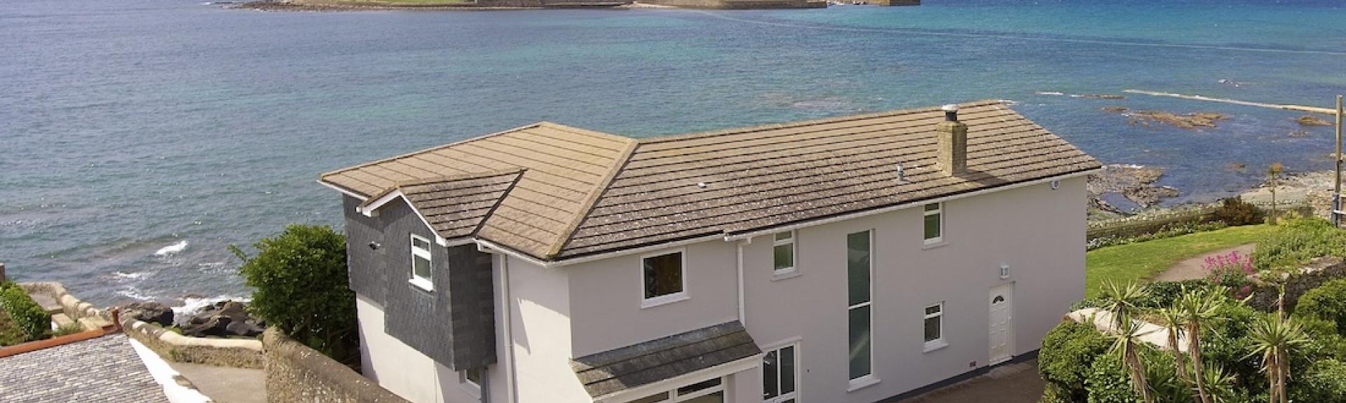 A large contemporary holiday home overlooks a beach and St. Michaels Mount in Cornwall
