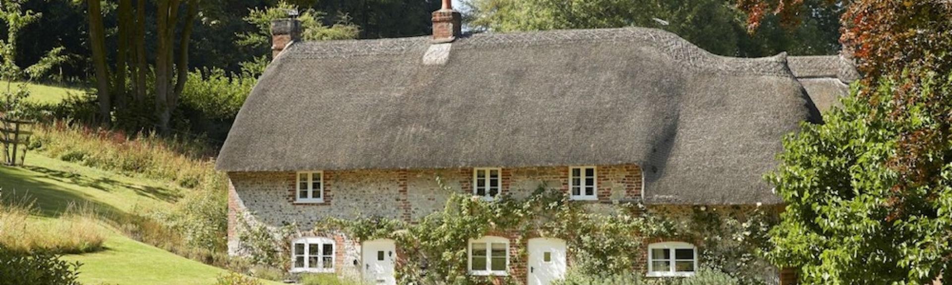 A large thatched cottage overlooks spacious, freshly-mown lawns.