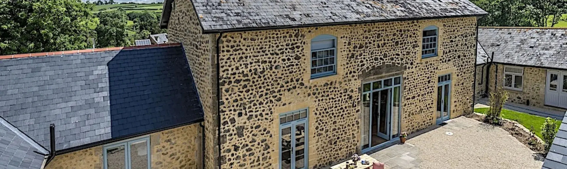 A stone, 2-storey, Dorset barn conversion overlooks a courtyard.
