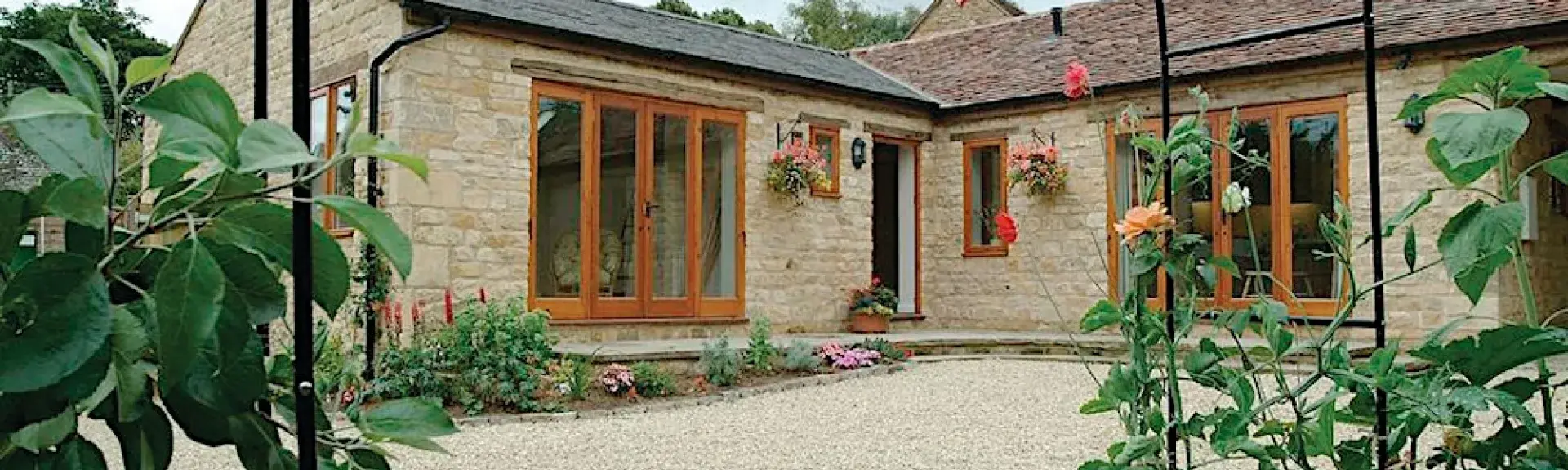 L-shaped single-storey exterior of a Warwickshire holiday cottage overlooking a courtyard.