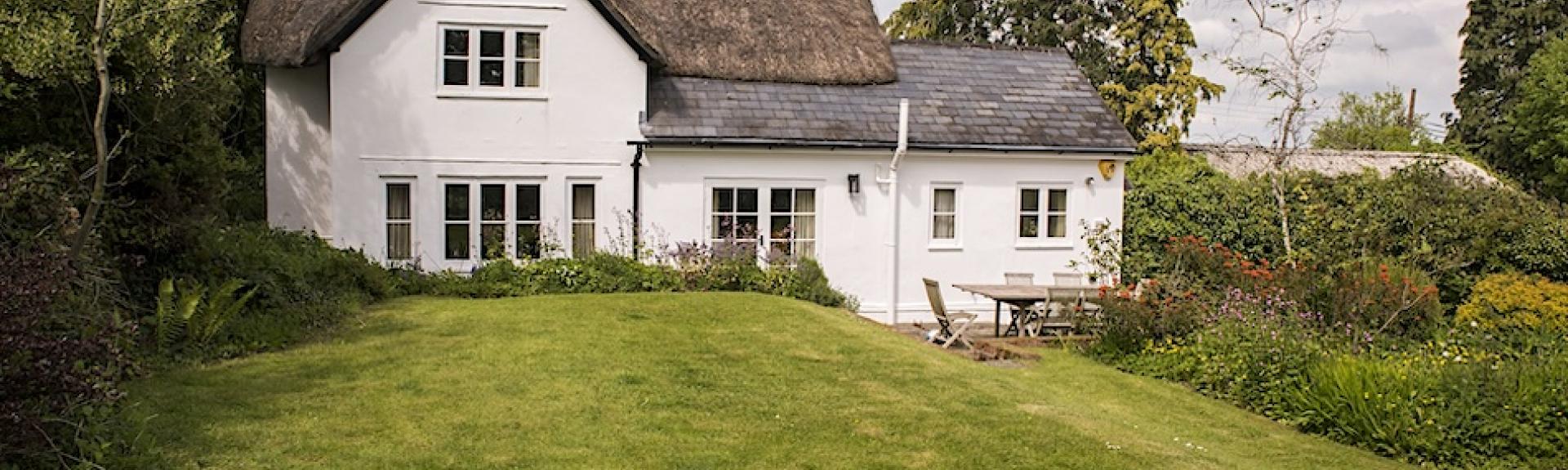 A partially thatched Dorset cottage overlooks a large and secure lawned garden